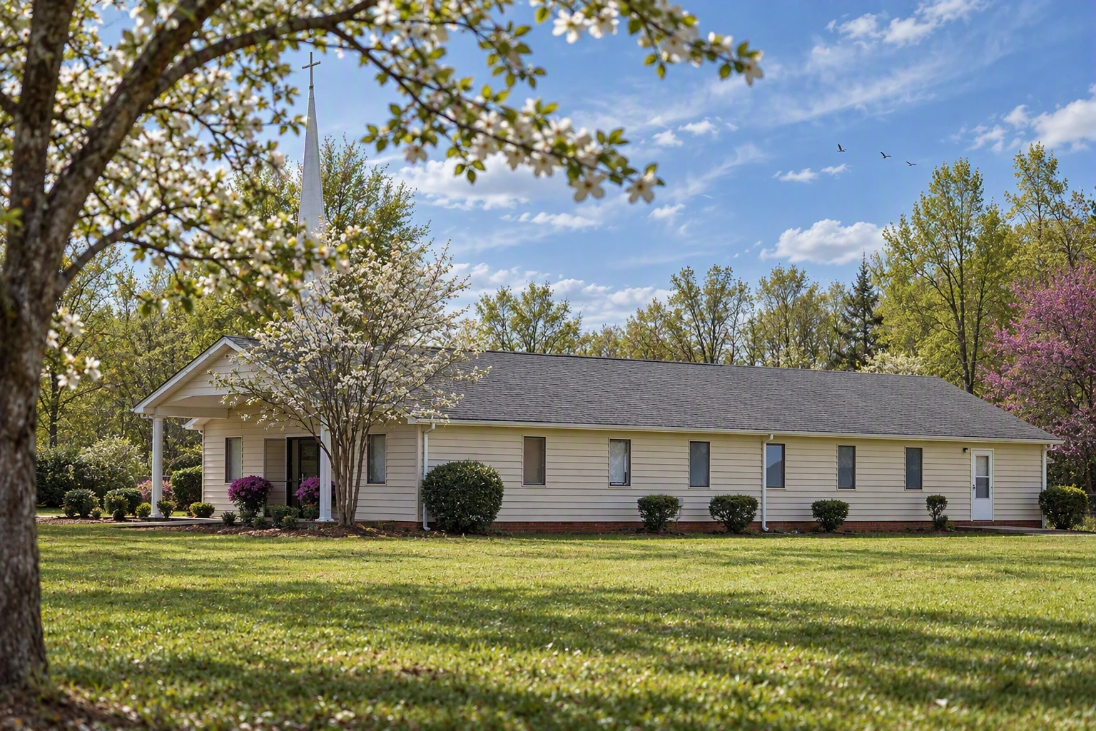 Clover Community Church building surrounded by flowering trees and a green lawn